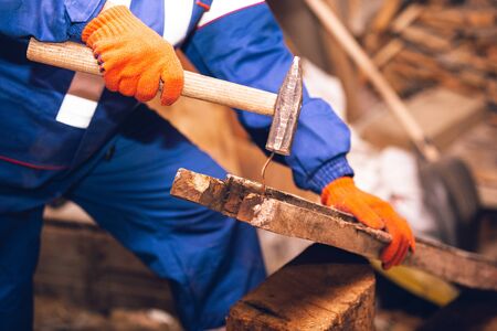 Closeup of repairman in uniform, professional builder working using construction equipment. Process...
