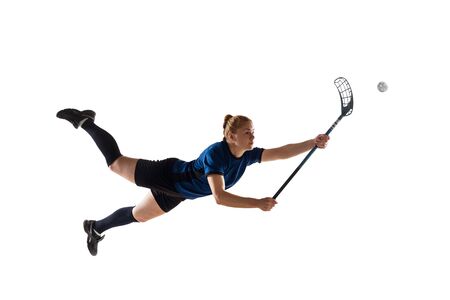 Floorball female player isolated on white studio background. Action and motion, movement, healthy lifestyle and overcoming concept. Young caucasian woman in sportwear training, practicing the game.の写真素材