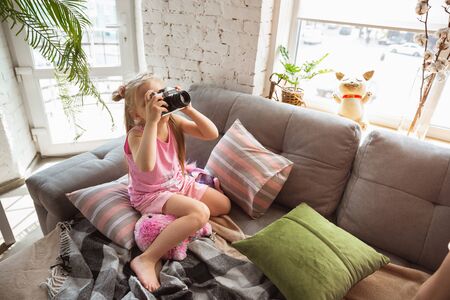 Quiet little girl playing in a bedroom in cute pajama, home style and comfort. Cute caucasian girl...
