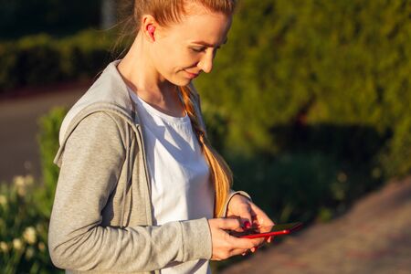 Young female runner, athlete resting after jogging in the city street in spring sunshine. Beautiful...