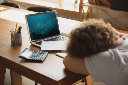 Caucasian upset and despair man watching financial and economical graphs going down during...