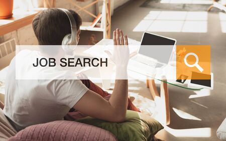 Man looking for a job during worldwide crisis. Find a job online. Business, internet and networking concept. Caucasian man looks through vacancies and sends resumes, needs to earn. Modern search bar.の写真素材
