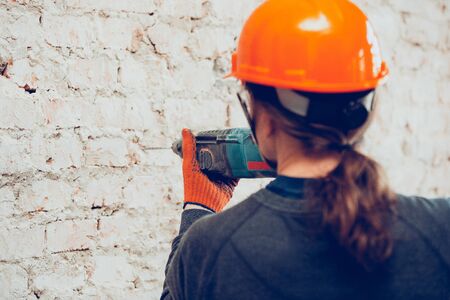 Closeup of repairman in uniform, professional builder working using construction equipment. Process...