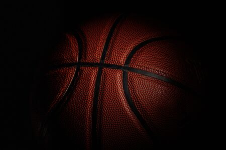 Basketball ball. Professional sport equipment isolated on black studio background. Concept of sport, leadership, competition, healthy lifestyle in motion and action, training. Close up, copyspace.の写真素材
