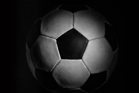 Soccer ball. Professional sport equipment isolated on black studio background. Concept of sport, leadership, competition, healthy lifestyle in motion and action, training. Close up, copyspace.の写真素材