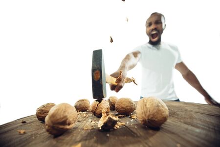 Amazing african-american man preparing unbelievable food with action, details and bright emotions, professional cook isolated on white studio background. Modern kitchen, artwork. Close up, wide angle.の写真素材