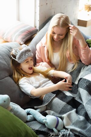 Mother and daughter, sisters have quite, beauty and fun day together at home. Comfort and togetherness. Concept of childhood, happiness, familys weekend, friendship, pajamas party. Domestic lifestyle.の写真素材