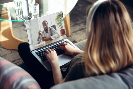 Young woman getting online medical help and advice during videocall with doctor checking symtoms...