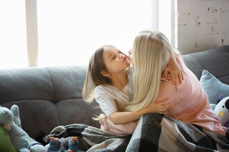Mother and daughter, sisters have quite, beauty and fun day together at home. Comfort and togetherness. Concept of childhood, happiness, familys weekend, friendship, pajamas party. Domestic lifestyle.の写真素材