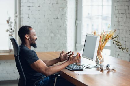 Angry. Young man, businessman working in office, looking on blank black computer screen, monitor. Copyspace for your ad. Finance, business, work, gadgets and tech concept. Freelance, remote worker.の写真素材