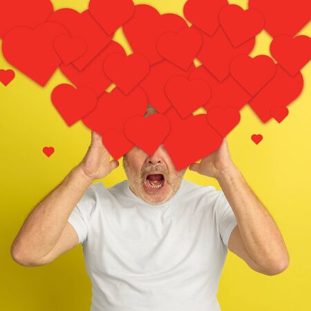 Whats in your head. Senior man with big speech bubbles on his head like a hairstyle made of hearts. Creative contemporary artwork. Daily thoughts, falling in love, crazy loves something, shocked.の写真素材