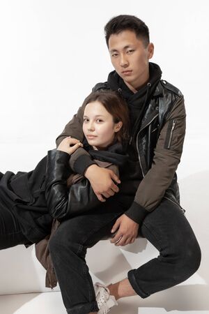 Street style. Trendy fashionable couple isolated on white studio background. Stylish woman and man...