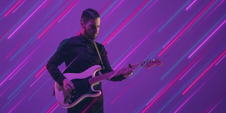Musician with guitar impovising. Creative portrait with copyspace. Neon lighted, colored portrait...
