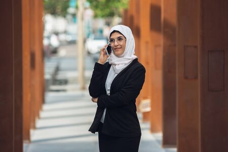 Talking on phone. Beautiful muslim successful businesswoman portrait, confident happy CEO, leader,...