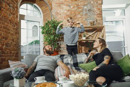 Weekend. Happy family at home spending time together. Having fun, look cheerful and lovely. Mother, father and son playing, talking, laughting. Childhood, domestic life, togetherness concept.の写真素材