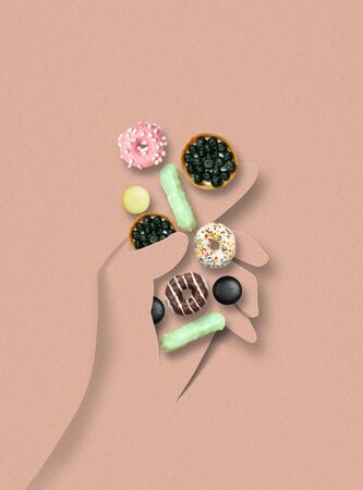 Human hand made of paper holding colorful donuts, cakes on pastel pink background. Contemporary colorful and conceptual bright art collage, mockup with copyspace. Sweets and tasty food.の写真素材
