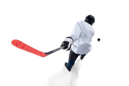 Unrecognizable male hockey player with the stick on ice court and white background. Sportsman wearing equipment and helmet practicing. Concept of sport, healthy lifestyle, motion, action. Top view.の写真素材