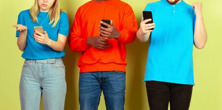 Group of friends using mobile smartphones. Teenagers addiction to new technology trends. Close up. Millenials texting, scrolling, chatting, watching video or shopping online. Connecting with devices.の写真素材