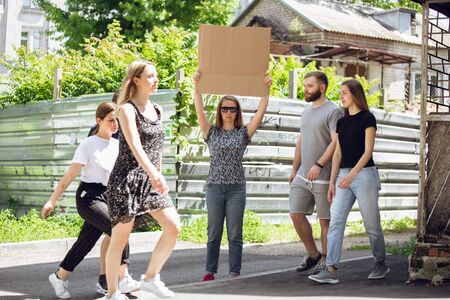 Dude with sign - woman stands protesting things that annoy her. Solo demonstration her right to talk free on the street with sign. Copyspace for text. Opinion heard by public. Social life, humor, meme.の写真素材