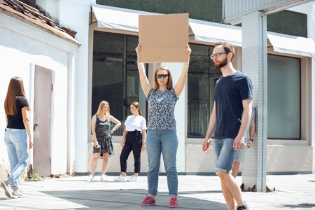 Dude with sign - woman stands protesting things that annoy her. Solo demonstration her right to talk free on the street with sign. Copyspace for text. Opinion heard by public. Social life, humor, meme.の写真素材