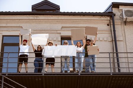 Diverse group of people protesting with blank sign. Protest against human rights, abuse of freedom, social issues, actual problems. Men and women on the street look angry, screaming. Copyspace.の写真素材