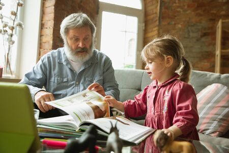 Grandfather and grandchild playing together at home. Happiness, family, relathionship, learning and...