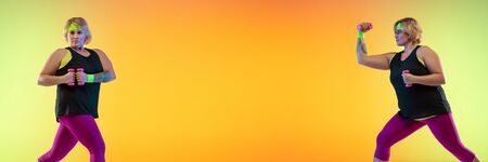 Young caucasian plus size female models training on gradient orange background in neon light. Doing...