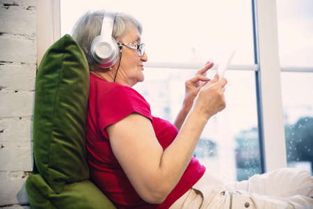 Player. Mature woman spending time being quarantined - caucasians woman using modern gadgets,...