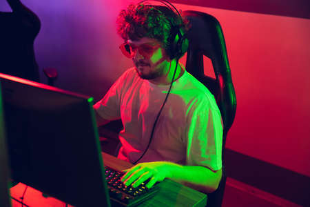 Cyber sport. Fully concentrated professional cybersport gamer playing important match. Caucasian...