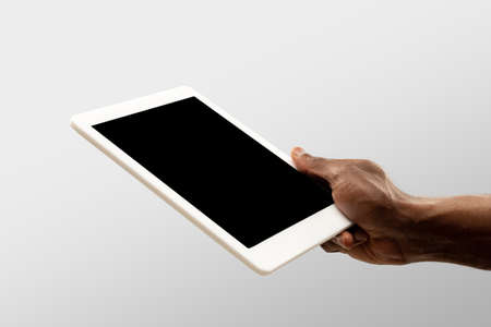 Comfort watching. Close up male hands holding tablet with blank screen during online watching of...