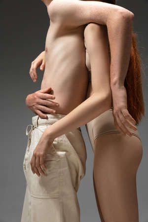 Close up. Fashion portrait of beautiful redhead couple isolated on grey studio background. Concept of male beauty, skin care, fashion and style. Artwork, modern and trendy portrait. Attractive models.の写真素材