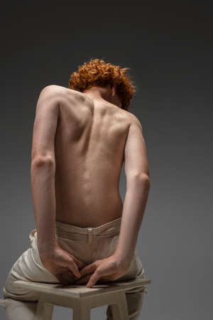 Clear reality. Fashion portrait of beautiful redhead man isolated on grey studio background. Concept of beauty, skin care, fashion and style. Artwork, modern and trendy portrait. Attractive model.の写真素材