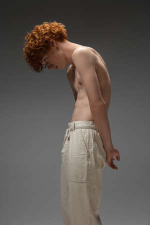 Clear reality. Fashion portrait of beautiful redhead man isolated on grey studio background. Concept of beauty, skin care, fashion and style. Artwork, modern and trendy portrait. Attractive model.の写真素材