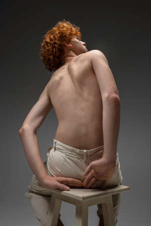 Clear reality. Fashion portrait of beautiful redhead man isolated on grey studio background. Concept of beauty, skin care, fashion and style. Artwork, modern and trendy portrait. Attractive model.の写真素材