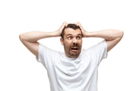 Scared. Young caucasian man with funny, unusual popular emotions and gestures isolated on white...