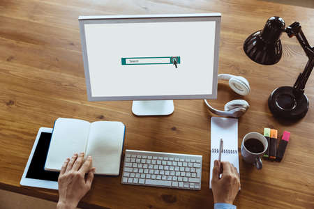 Search bar, copyspace on monitor screen. Man looking for job home during COVID-19 quarantine, remote office concept. Unemployed guy sitting in front of monitor, writing a resume, doing notes. Top view.の写真素材