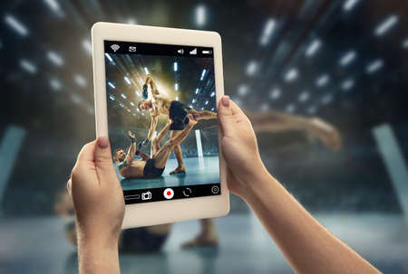 Close up hands holding tablet viewing sport, MMA online streaming of championship. New rules during coronavirus outbreak and countries lockdown. Concept of sport, competition, technologies.の写真素材