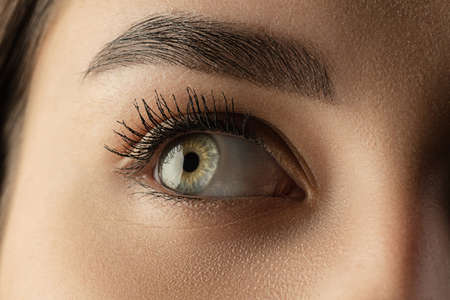 Close up of face, eyes of beautiful caucasian young woman, clear look. Human emotions, facial expression, cosmetology, body and skin care concept. Hopeful, dreamful look, sight. Psychology, fashion.の写真素材