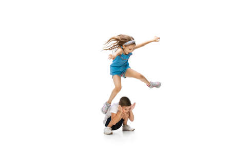 Happy kids, little and emotional caucasian boy and girl jumping and running isolated on white...