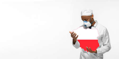 Beautiful african-american doctor cares about Poland over white studio background. Copyspace. Concept of healthcare and medicine, taking care, treatment, diagnostics during coronavirus outbreak.の写真素材