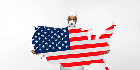 Beautiful african-american doctor cares about USA over white studio background. Copyspace. Concept of healthcare and medicine, taking care, treatment, diagnostics during coronavirus outbreak.の写真素材