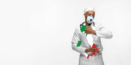 Beautiful african-american doctor cares about Italy over white studio background. Copyspace. Concept of healthcare and medicine, taking care, treatment, diagnostics during coronavirus outbreak.の写真素材