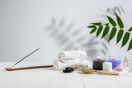 Beautiful spa composition on massage table in wellness center, copyspace. Accessories for relaxing treatments and personal care. Towels, oils, serum, sea salts and scrubs. Decorative candles.の写真素材