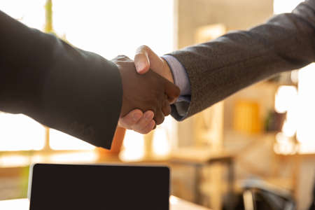 Close up of businessmen shaking hands in conference room, making a deal, successful agreement or cooperation. Concept of finance and business, contracts, partnership, community and teamwork.の写真素材