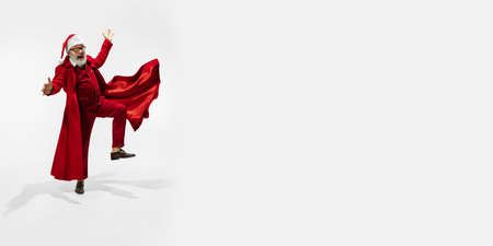 Dancing man. Modern stylish Santa Claus in red fashionable suit isolated on white background. Looks like a rockstar. New Year and Christmas eve, celebration, holidays, winters mood, fashion. Flyerの写真素材
