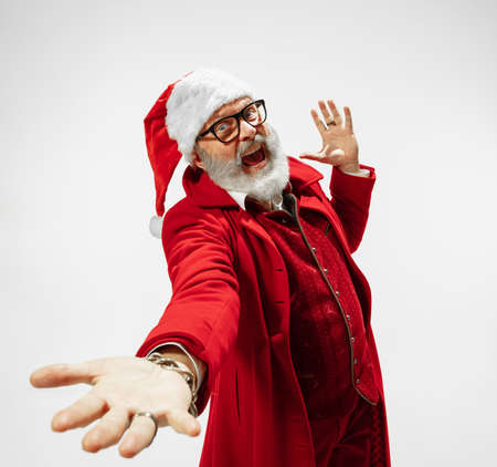 Dancing man. Modern stylish Santa Claus in red fashionable suit isolated on white background. Looks like a rockstar. New Year and Christmas eve, celebration, holidays, winters mood, fashion.の写真素材