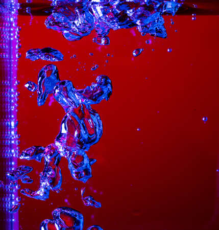 Close up view of the cold and fresh cola with bright bubbles in neon light. Texture of cooling...
