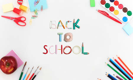 Colorful school supplies corner border over a white background with words Back to school. Pencils, paints, scissors, stickers. Education, school time, childhood concept. Copyspace, ready for ad.の写真素材