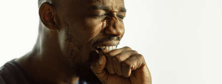 Crying. African-american young mans close up shot on studio background, flyer. Concept of human...