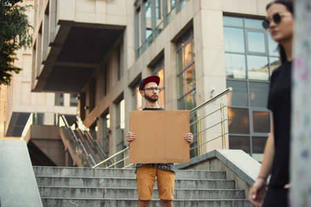 Dude with sign - man stands protesting things that annoy him. Solo demonstration his right to talk free on the street with sign. Copyspace for text. Opinion heard by public. Social life, humor, meme.の写真素材